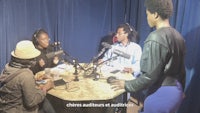 a group of people sitting around a table with microphones