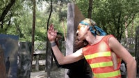 a man in an orange vest is pointing at a piece of art
