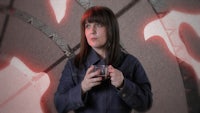 a woman holding a cup in front of a red background